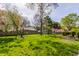 Lush backyard with green lawn, mature trees, garden shed, and perimeter fencing at 7859 N Chester Ave, Indianapolis, IN 46240