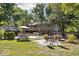 Green house backyard with an in-ground pool, outdoor dining, patio area, and mature trees at 7859 N Chester Ave, Indianapolis, IN 46240