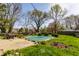 Landscaped backyard featuring a covered swimming pool, patio furniture, and mature shade trees at 7859 N Chester Ave, Indianapolis, IN 46240