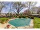 Spacious backyard with a pool covered for the season, surrounded by mature trees and landscaping at 7859 N Chester Ave, Indianapolis, IN 46240