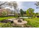 Backyard featuring stone firepit, covered pool, and perimeter landscaping at 7859 N Chester Ave, Indianapolis, IN 46240