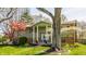 Charming green home featuring a bright blue front door surrounded by mature trees at 7859 N Chester Ave, Indianapolis, IN 46240