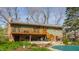 Back exterior featuring wood deck, access stairs, lower patio and covered pool at 7859 N Chester Ave, Indianapolis, IN 46240