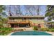 Back exterior of home with wood deck, brick facade and covered pool at 7859 N Chester Ave, Indianapolis, IN 46240