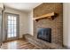 Living room featuring brick fireplace with hearth and french door to exterior at 7859 N Chester Ave, Indianapolis, IN 46240
