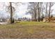 Large backyard with play set, mature trees, and ample space for outdoor activities and entertaining at 8020 N Meridian N St, Indianapolis, IN 46260