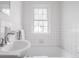 Neat bathroom featuring tiled tub, window, and chrome faucet at 8020 N Meridian N St, Indianapolis, IN 46260
