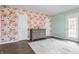Bright bedroom featuring a floral accent wall, dark wood floors, a neutral rug, and mint green walls at 8020 N Meridian N St, Indianapolis, IN 46260