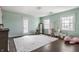 Bright bedroom with a neutral rug, dark wood floors, and mint green walls and plenty of natural light at 8020 N Meridian N St, Indianapolis, IN 46260
