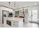 Kitchen with stainless steel appliances, quartz countertops, white cabinets, pendant lights, and barstool seating at 8020 N Meridian N St, Indianapolis, IN 46260
