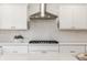 A chef's kitchen is well appointed with a tile backsplash, white cabinets, and stainless steel appliances at 8020 N Meridian N St, Indianapolis, IN 46260