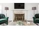Elegant living room with a fireplace, large-screen TV, two armchairs, and floor lamps at 8020 N Meridian N St, Indianapolis, IN 46260