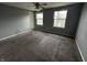 Bedroom featuring two windows, carpet flooring, a ceiling fan, and light gray walls at 8054 Harvest Ln, Indianapolis, IN 46256