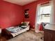Vibrant bedroom with red walls, a single bed, and a desk for studying at 810 Fabyan Rd, Indianapolis, IN 46217