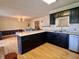 Kitchen with black cabinets, tiled backsplash, and a view into dining room at 810 Fabyan Rd, Indianapolis, IN 46217