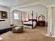Cozy main bedroom with four-poster bed, vintage vanity, and a relaxing sitting area at 810 Fabyan Rd, Indianapolis, IN 46217