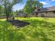 A large backyard with mature trees features a play set and fire pit for Gathering and friends to enjoy at 859 E Bunkerhill Rd, Mooresville, IN 46158