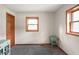 Bright bedroom featuring two wooden doors, gray carpet, and a mint accent table by the window at 859 E Bunkerhill Rd, Mooresville, IN 46158