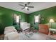 Bright bedroom with carpet, green walls, ceiling fan, and a crib at 859 E Bunkerhill Rd, Mooresville, IN 46158