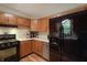 Bright kitchen offering stainless steel dishwasher, black refrigerator, and wood cabinets at 859 E Bunkerhill Rd, Mooresville, IN 46158