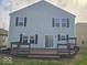 The back exterior has a wooden deck, dark shutters, and light gray siding at 10915 Mansfield Way, Ingalls, IN 46048