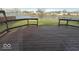 A brown wooden deck in the backyard offers a place to sit and enjoy the view of a small lake at 10915 Mansfield Way, Ingalls, IN 46048