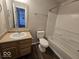 Bathroom featuring wood vanity with laminate top, toilet and tub/shower combo with white tile surround at 10915 Mansfield Way, Ingalls, IN 46048