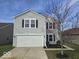 Attractive two-story home with gray siding, white garage door, and manicured landscaping at 10915 Mansfield Way, Ingalls, IN 46048