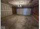 Empty garage featuring painted walls and a standard garage door with overhead lighting at 10915 Mansfield Way, Ingalls, IN 46048