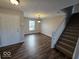 Inviting living room featuring new flooring, a staircase, and abundant natural light from the window at 10915 Mansfield Way, Ingalls, IN 46048