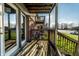 View of the back porch with wooden slats, brick facade and sunny lawn at 11931 E Welland St, Indianapolis, IN 46229