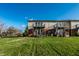Spacious backyard showcasing townhome exterior with balconies and lawn at 11931 E Welland St, Indianapolis, IN 46229