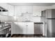 Updated kitchen features stainless steel appliances and white cabinets with contemporary hardware at 11931 E Welland St, Indianapolis, IN 46229