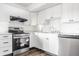 Well-lit kitchen features stainless steel appliances and white cabinets with dark hardware at 11931 E Welland St, Indianapolis, IN 46229
