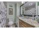 Bathroom with walk-in shower, wood cabinet, granite countertop, and natural light at 1231 S Pershing Ave, Indianapolis, IN 46221