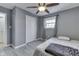 Comfortable bedroom boasts gray walls, a ceiling fan, and ample natural light from the window at 1231 S Pershing Ave, Indianapolis, IN 46221
