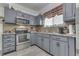Kitchen features gray cabinets, granite countertops and modern stainless steel appliances at 1231 S Pershing Ave, Indianapolis, IN 46221
