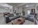 Open-concept living room with a large grey sectional sofa flowing into dining area with bright natural light at 1231 S Pershing Ave, Indianapolis, IN 46221