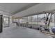 A screened-in patio with a table, chairs, and workout equipment that offers a view of the backyard at 1231 S Pershing Ave, Indianapolis, IN 46221
