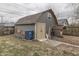 A gray shed with a window and double doors, surrounded by grass, a trashcan, and wooden fencing at 1231 S Pershing Ave, Indianapolis, IN 46221