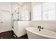 Bright bathroom features a modern tub, a glass-enclosed shower, and a window for natural light at 15628 Allegro Dr, Westfield, IN 46074