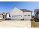 Spacious three-car garage with white doors and a wide driveway, providing ample parking at 15628 Allegro Dr, Westfield, IN 46074