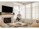 Bright living room with a cozy seating area, fireplace, and large windows with sheer curtains at 15628 Allegro Dr, Westfield, IN 46074