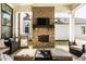 Covered patio boasts a brick fireplace, mounted TV, and comfortable lounge furniture for relaxing outdoors at 15628 Allegro Dr, Westfield, IN 46074