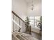 Elegant staircase with wood railing, black iron balusters, and a modern chandelier fixture at 15628 Allegro Dr, Westfield, IN 46074