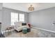Inviting living room area featuring a white loveseat, ottoman stools, and area rug at 16516 Wilsons Farm Dr, Fortville, IN 46040