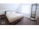 Cozy bedroom with neutral decor, a comfortable bed, and a clothing rack at 1715 Fletcher Ave, Indianapolis, IN 46203
