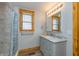 Bathroom with a marble vanity, marble tiled shower, and a wood trimmed window at 241 S Walnut St, Jamestown, IN 46147