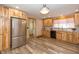 Modern kitchen with stainless steel appliances, wooden cabinets, and laminate flooring at 241 S Walnut St, Jamestown, IN 46147