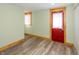 Bright room featuring light green paint, wood trim, vinyl floor, and a red door at 241 S Walnut St, Jamestown, IN 46147